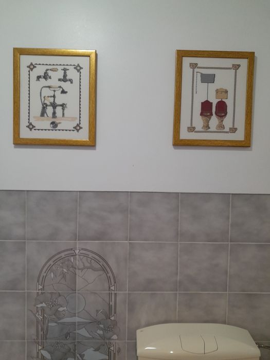 Dois quadros /emoldurados dourado e ,em ponto cruz.