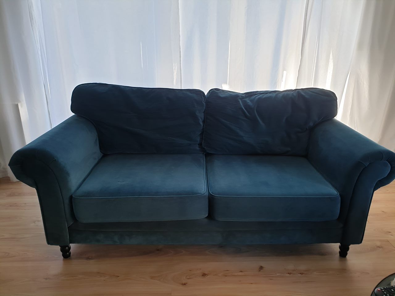 Nowoczesna sofa w szmaragdowym kolorze.