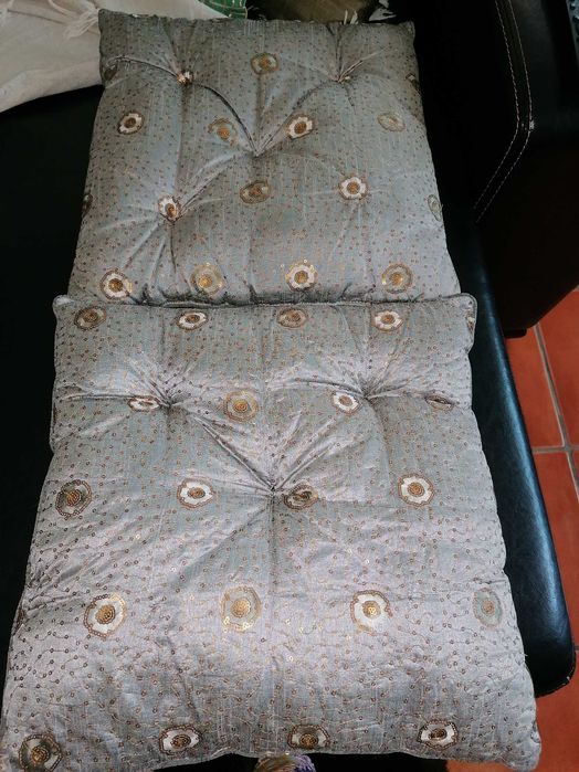 Cortinados acetinados e duas almofadas decorativas.