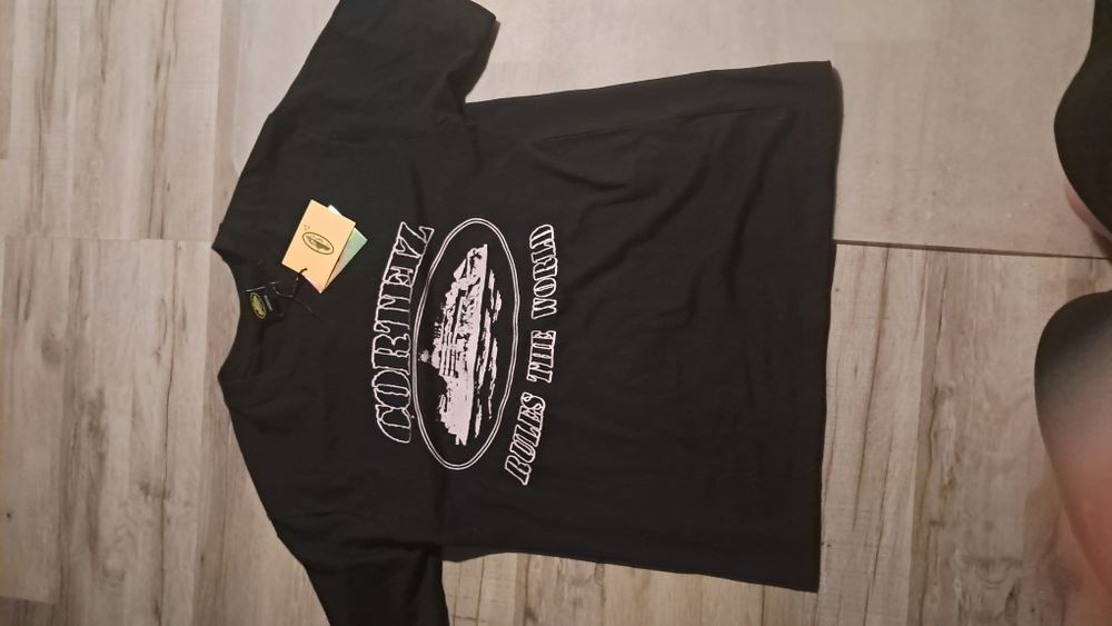 Nowa koszulka corteiz, czarna z jasno różowymi napisami.