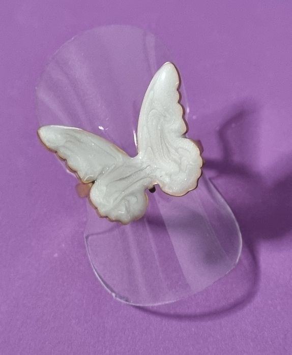Anel dourado, em açol, com borboleta branca esmaltada. Ajustável