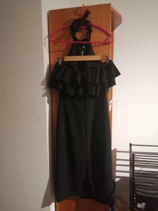 Vestido preto, elegante, com folho no peito. Alça a atar no pescoço.