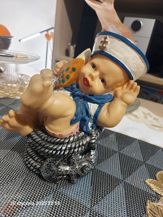 Figurka dekoracyjna chłopiec w marynarskiej czapce z łódką na plaży