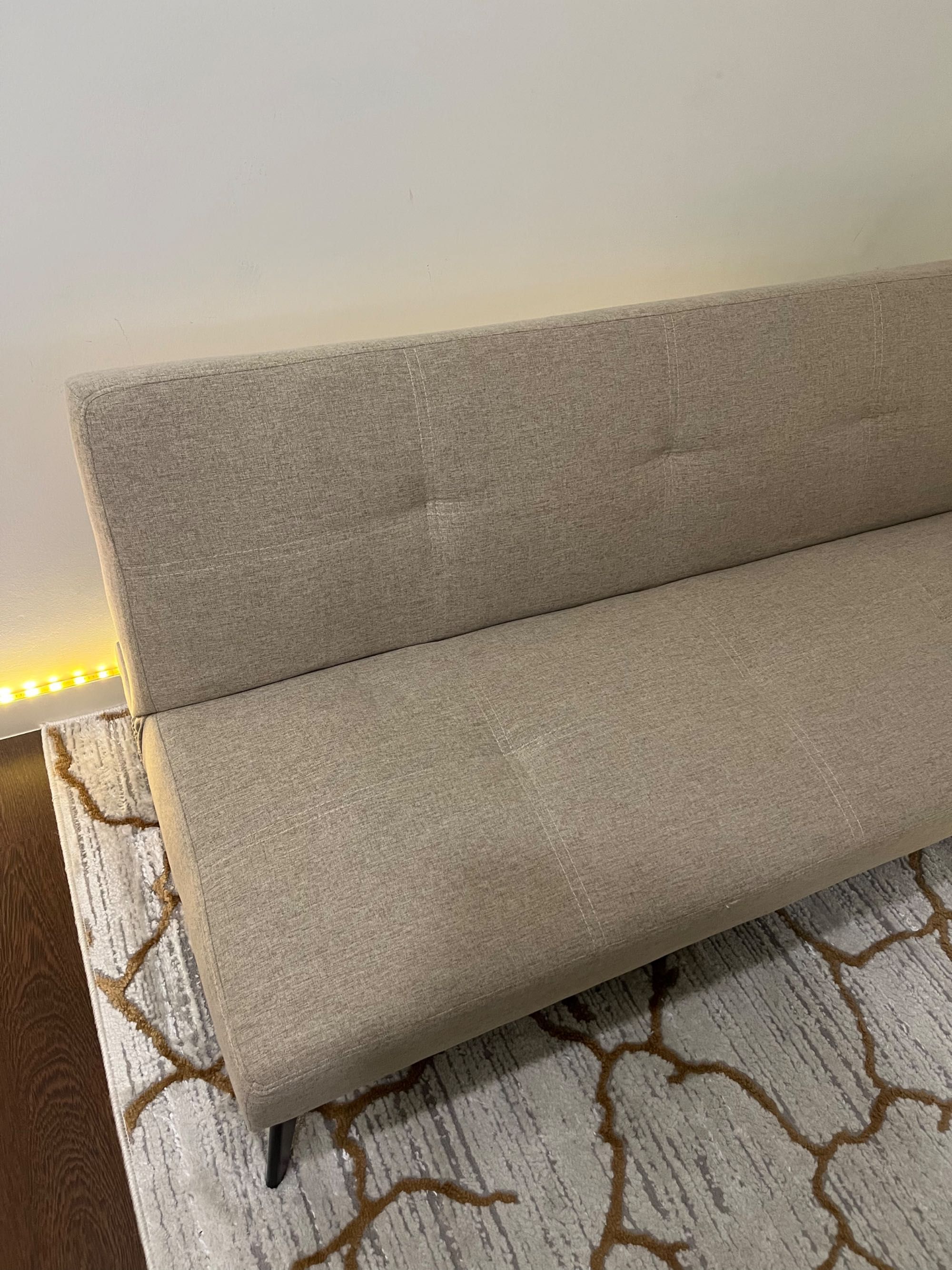 Sofá-cama bege com pernas pretas