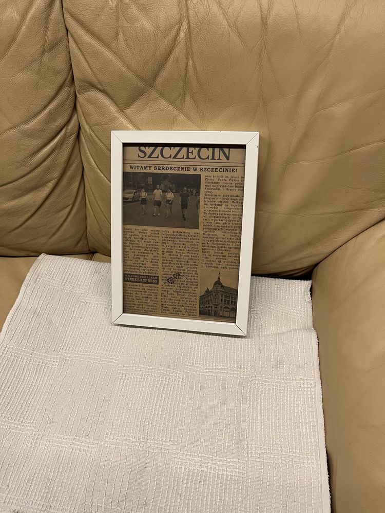Ramka biała z wycinkami z gazety w środku o Szczecinie z nożką