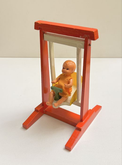 Stara miniaturowa lalka na huśtawce