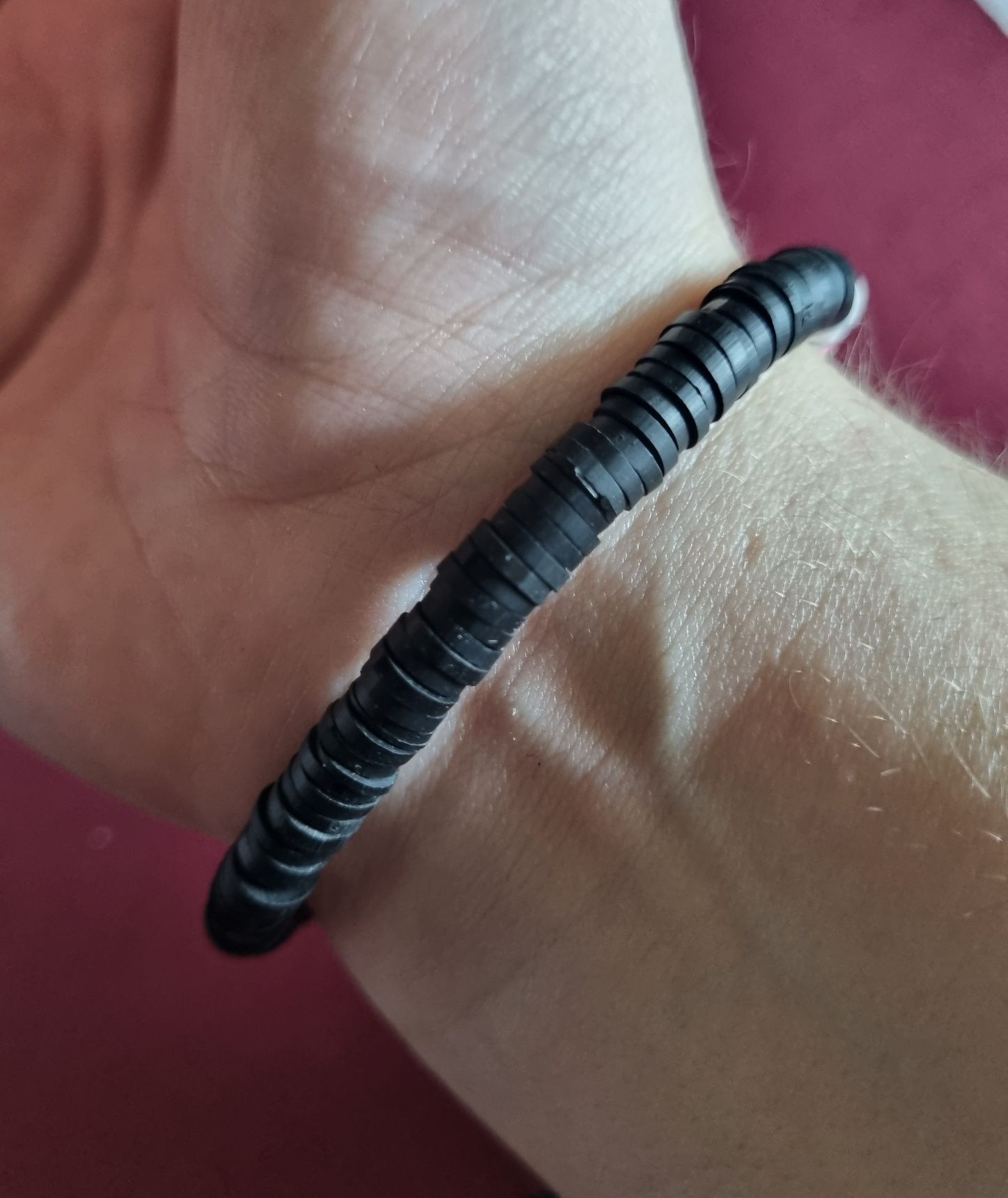 Pulseira elástica em tons de preto e multicor. Com olho de proteção