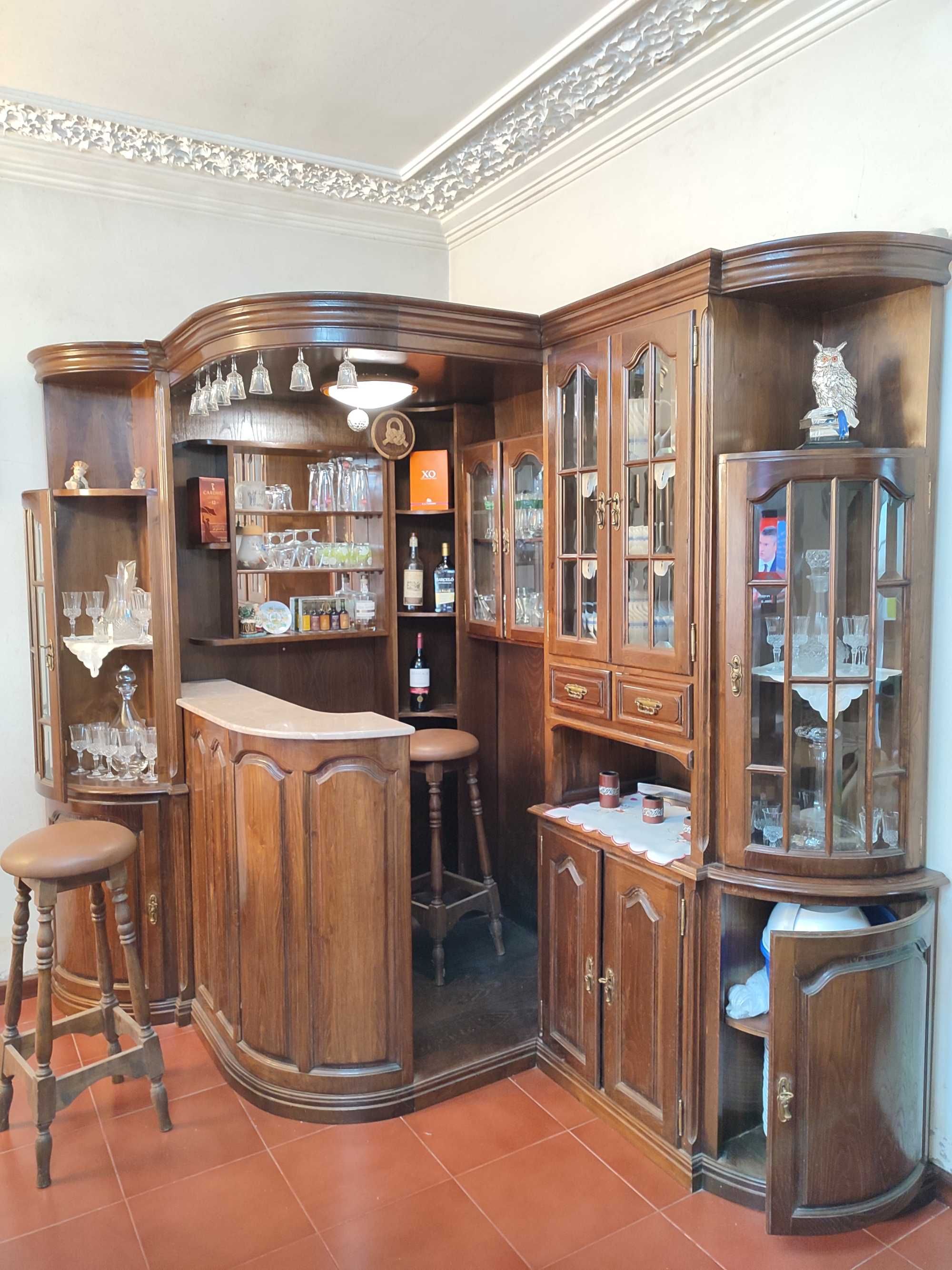 Bar de canto com vidros facetados, balcão, vitrines e 2 bancos