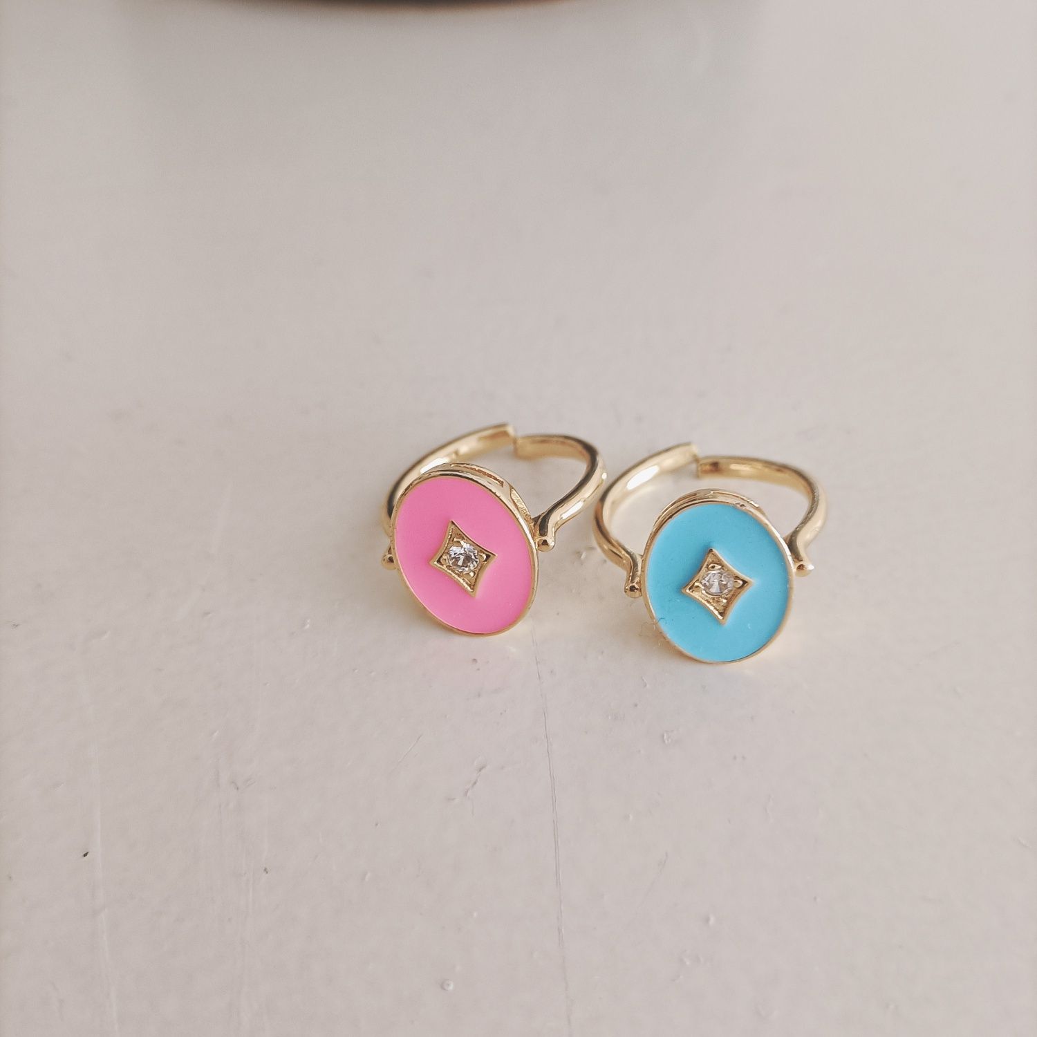 Dois anéis em latão dourado e esmalte rosa e azul.