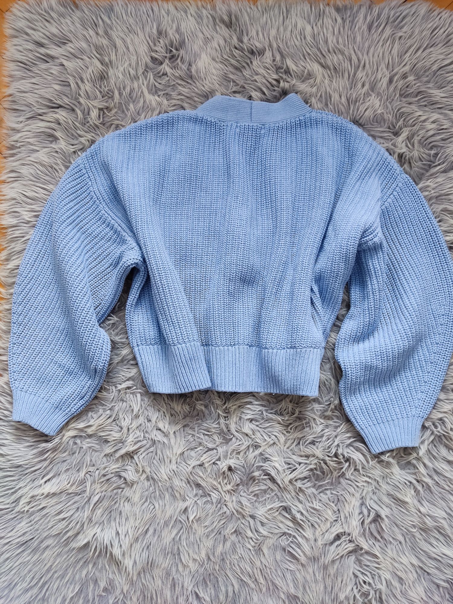 Błękitny sweter oversize zapinany na guziki bufiaste rękawy