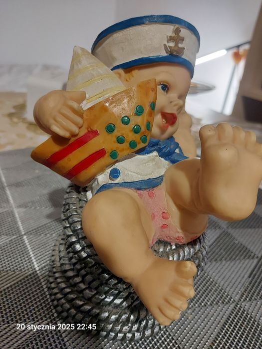 Figurka dekoracyjna chłopiec w marynarskiej czapce z łódką na plaży