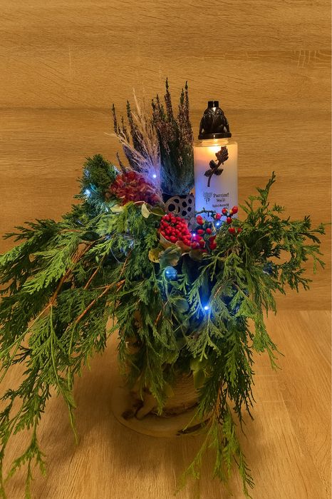 Stroik na grób wykonany na pieńku drzewa z gałązkami z choinki itp.