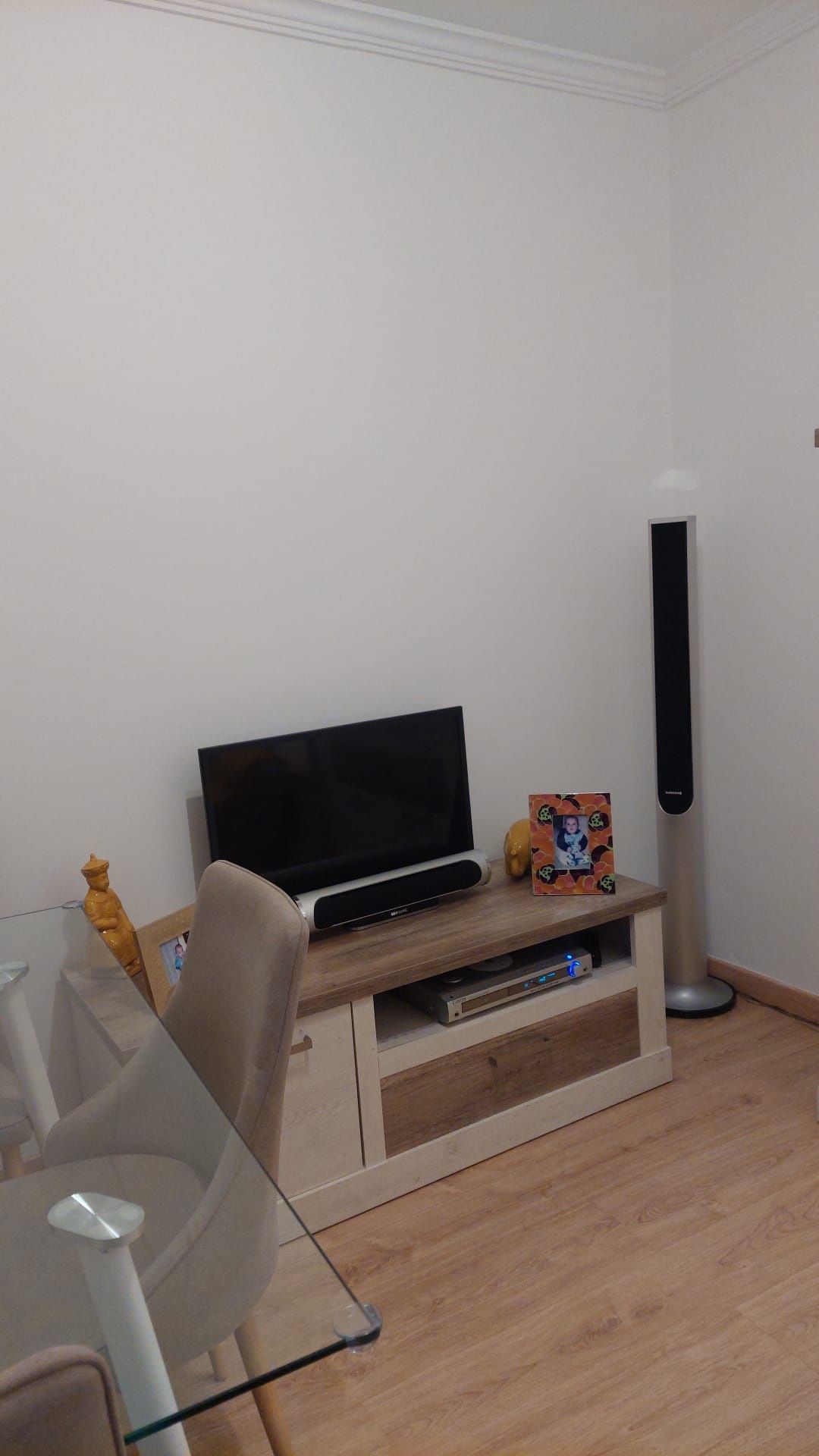 Sala composta por mesa, cadeiras e dois móveis .