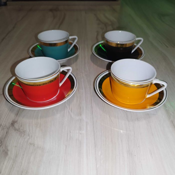 Zestaw kolorowych filiżanek z talerzykami.