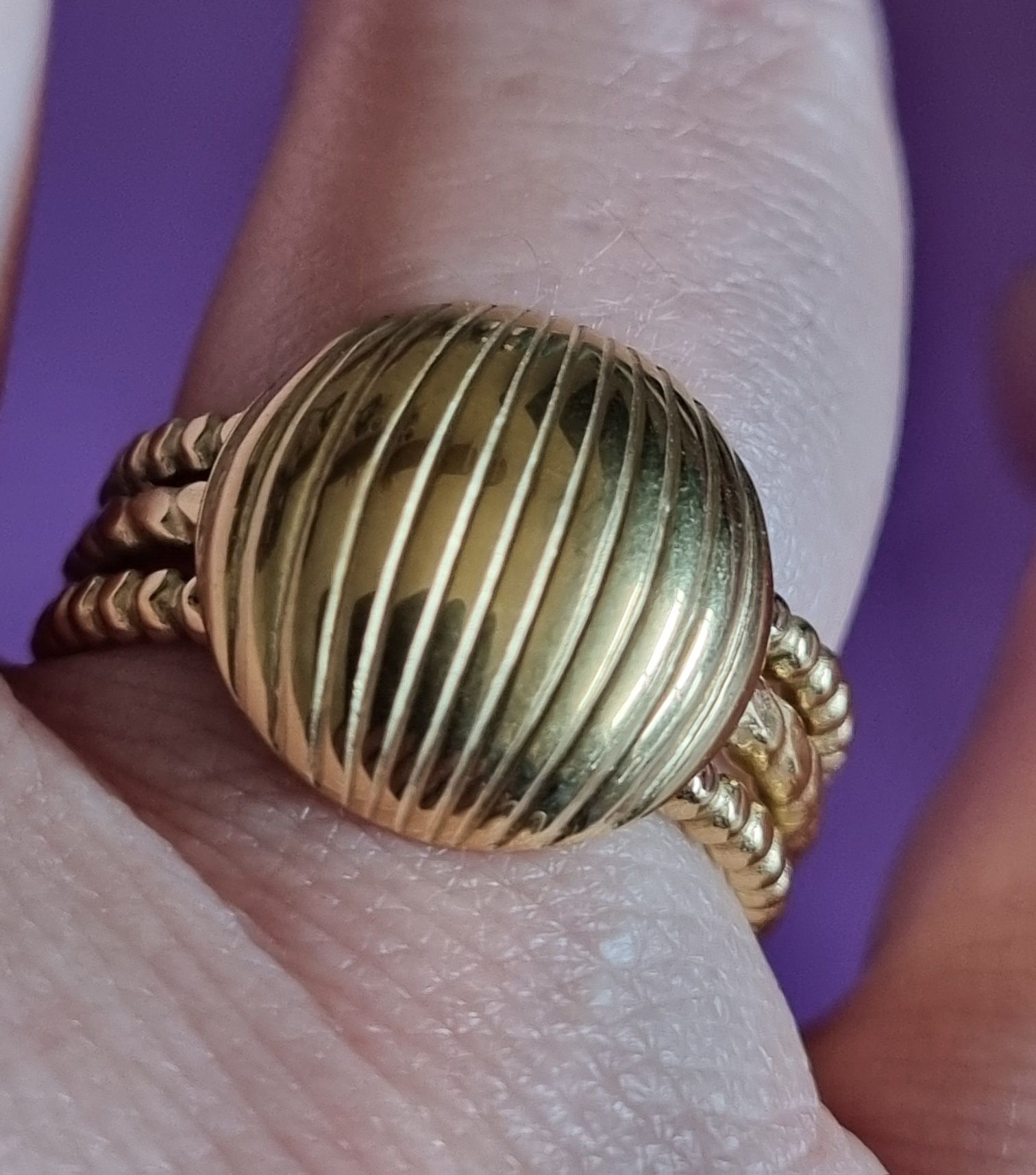 Anel dourado, em aço, com meia bola riscada. Ajustável