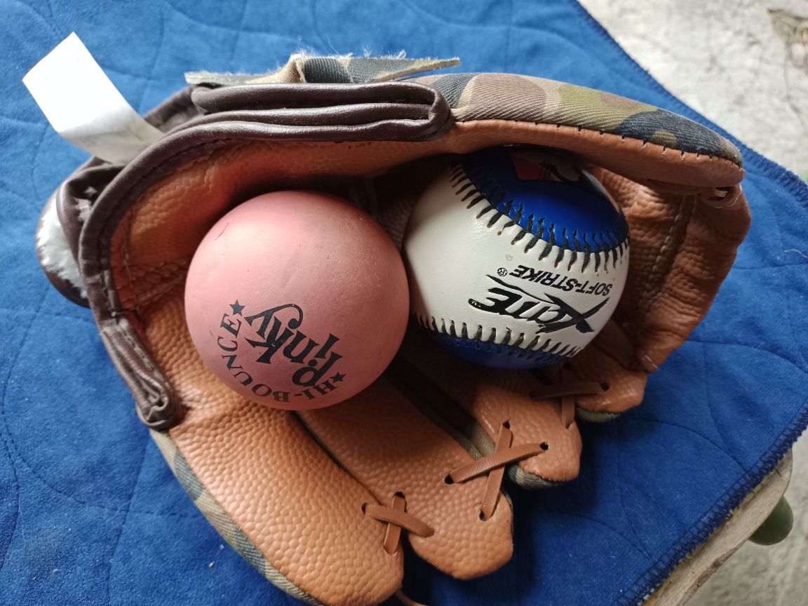 Детская бейсбольная перчатка и мячики.