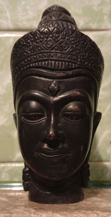 Zabytkowa figura - glowa Buddy na kamieniu