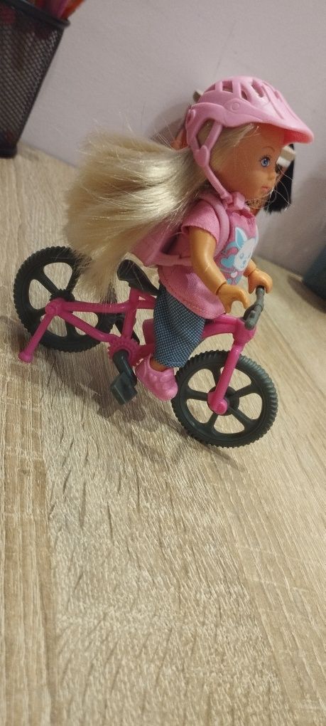 Lalka na rowerku z pieskiem w plecaku