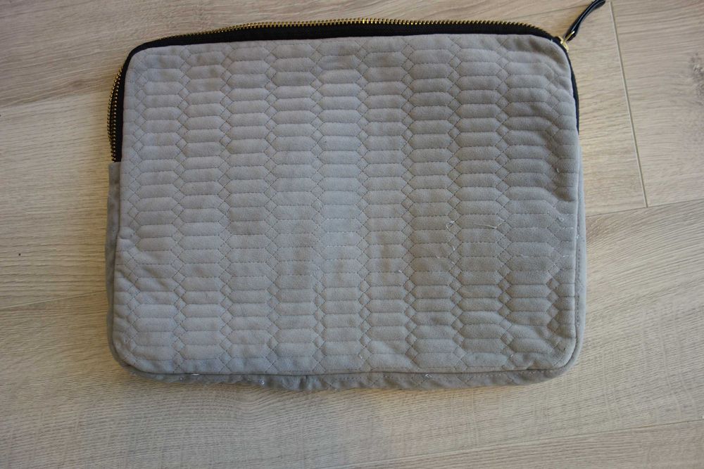 popielate etui na laptop 
zapinane na zamek błyskawiczny