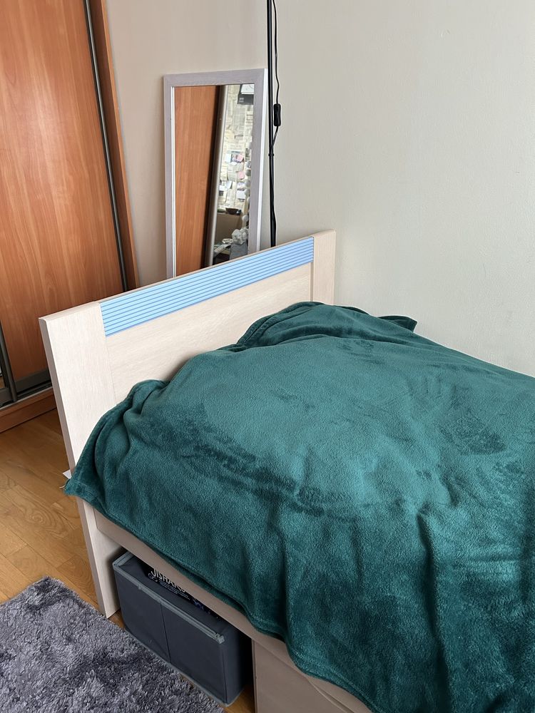 Lóżko pojedyncze z niebieskimi listwami i szufladą