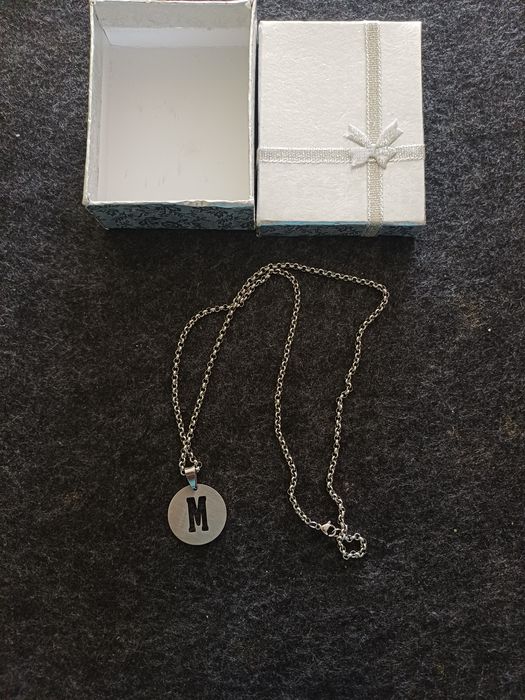 Fio prateado com a letra M