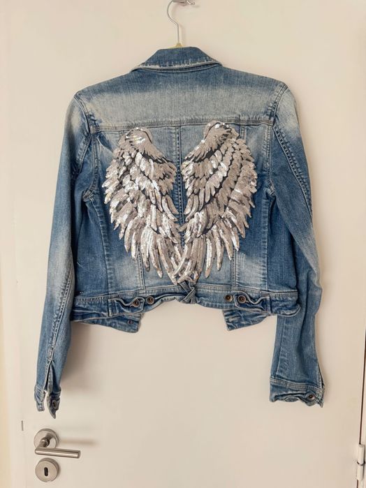 Blusão de ganga com asas prateadas aplicadas