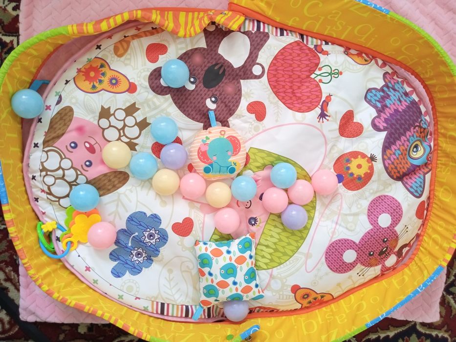 Новий розвиваючий килимок для немовляти запакований в коробці.