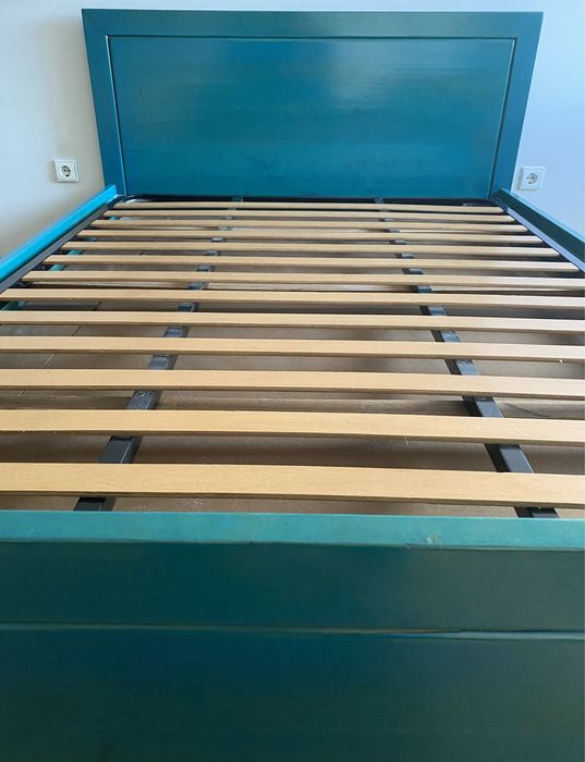 Cama em madeira de castanho pintada em azul a ver o veio da madeira