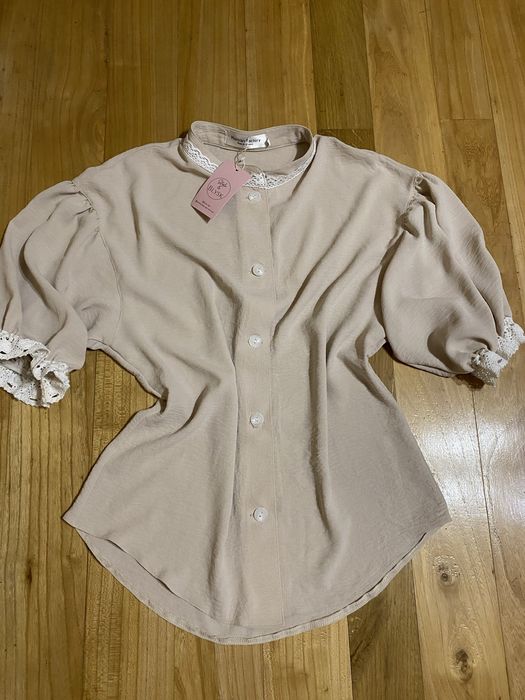 Бежева блузка з короткими рукавами та мереживними деталями