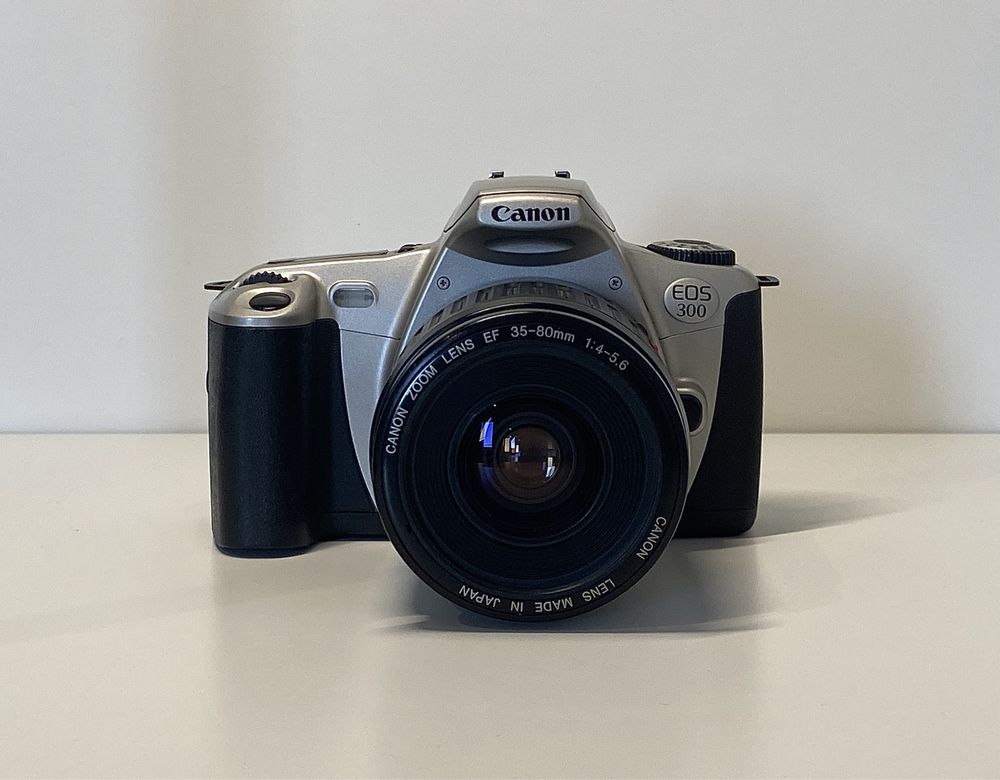 Aparat analogowy Canon EOS 300 z obiektywem i pokrowcem.