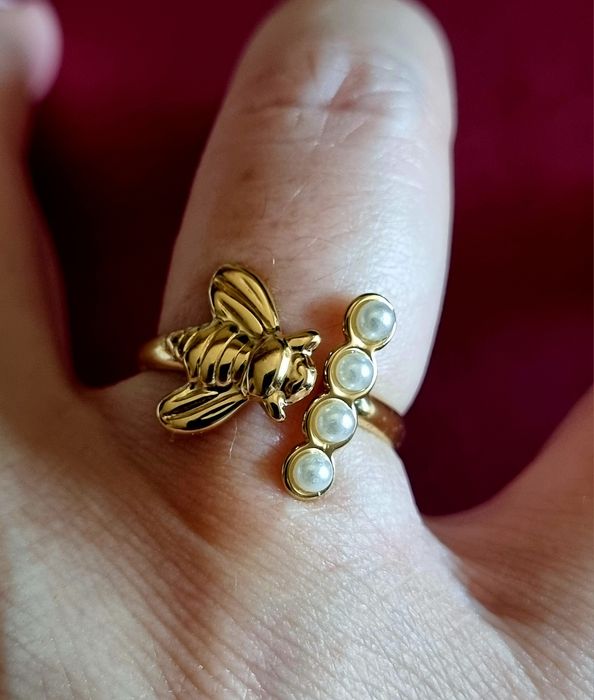 Anel dourado, em aço, com abelha e 4 micropérolas. Ajustável
