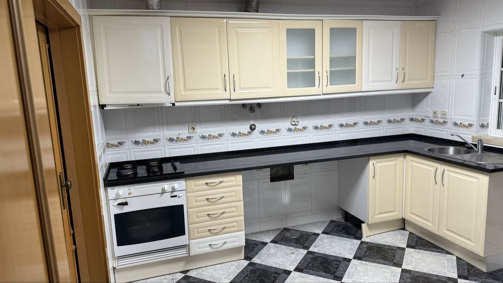 Armarios e bancada de cozinha branco com pedra preta