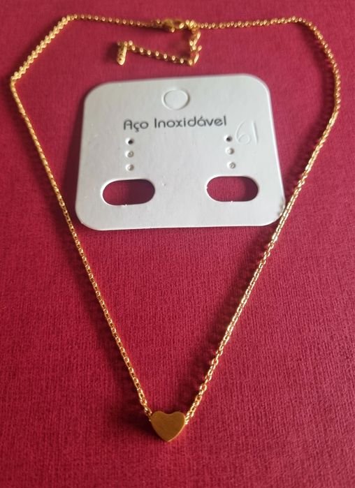 Colar dourado, em aço, com pequeno coração fixo. Tem extensor