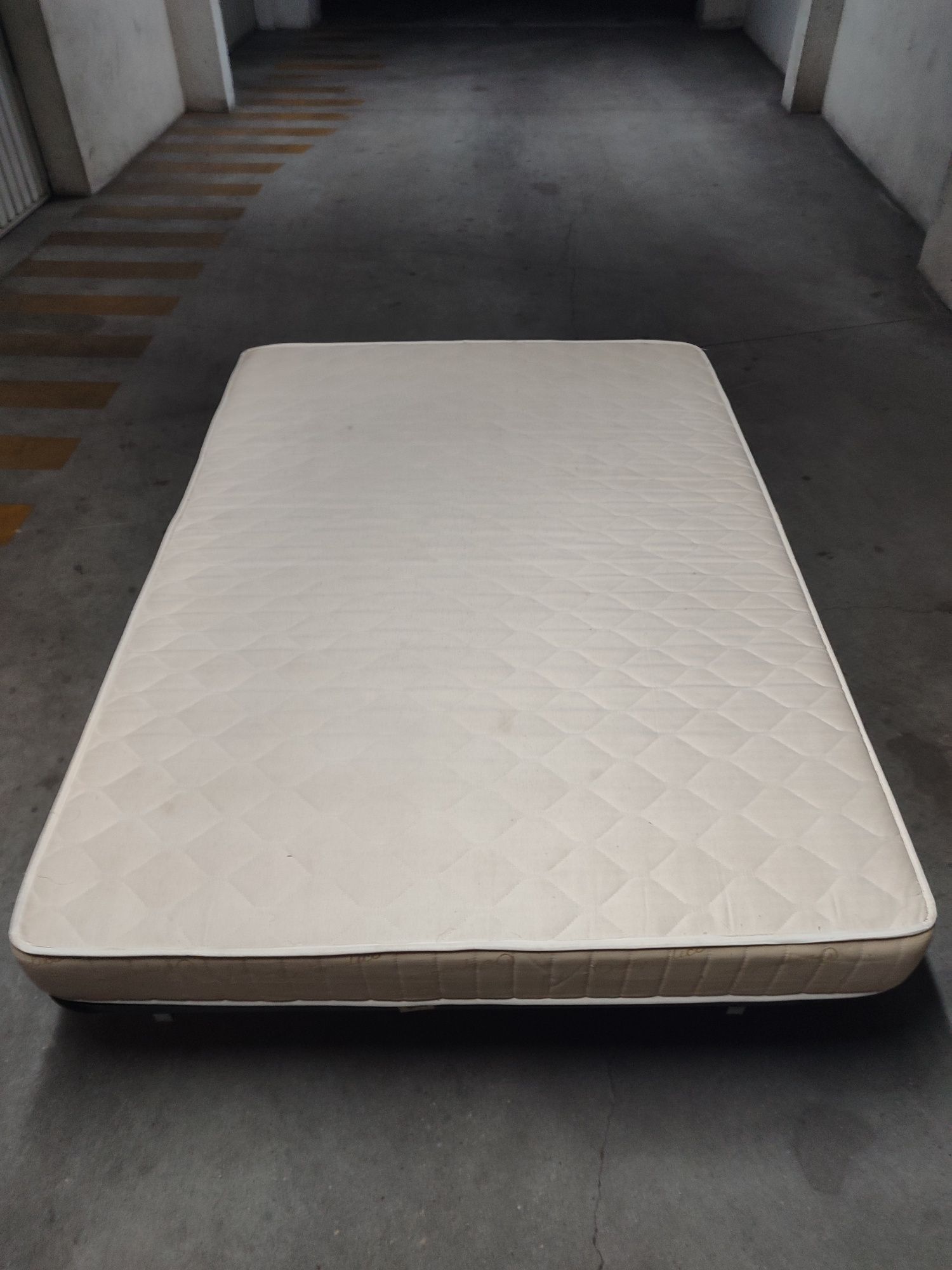 Estrado de cama metálico com colchão.