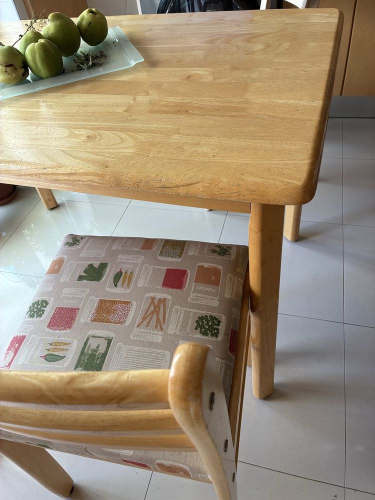 Mesa de cozinha e cadeiras de madeira com assentos estofados