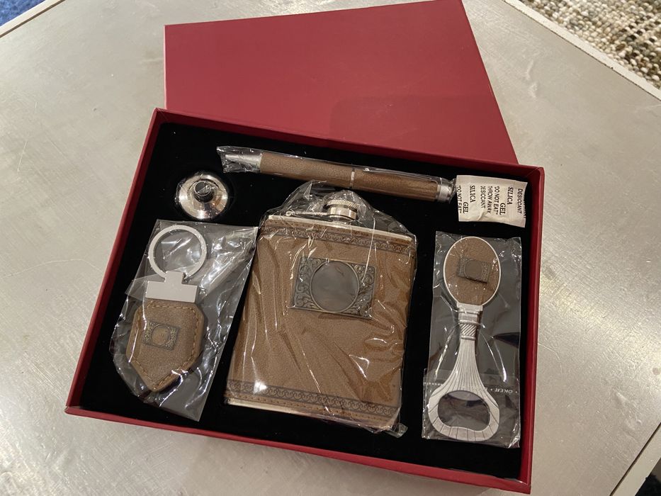 Caixa com caneta, garrafa, abre latas e porta chaves