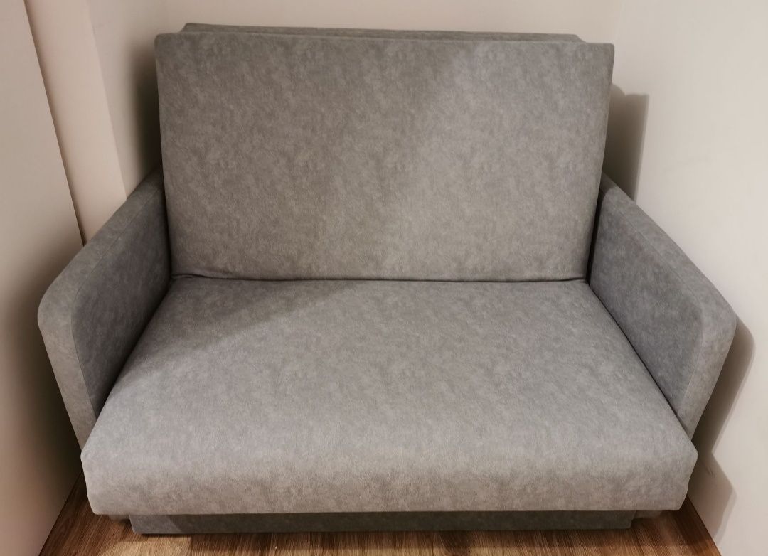 Rozkładana szara sofa z pojemnikiem na pościel