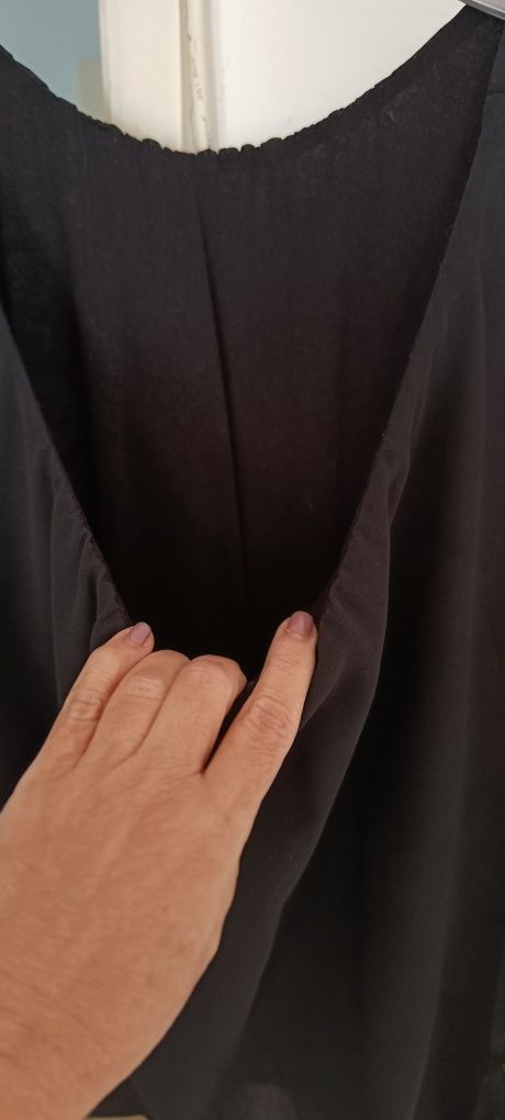 Blusa preta aberta de lado. Tem um forro em algodão por baixo.