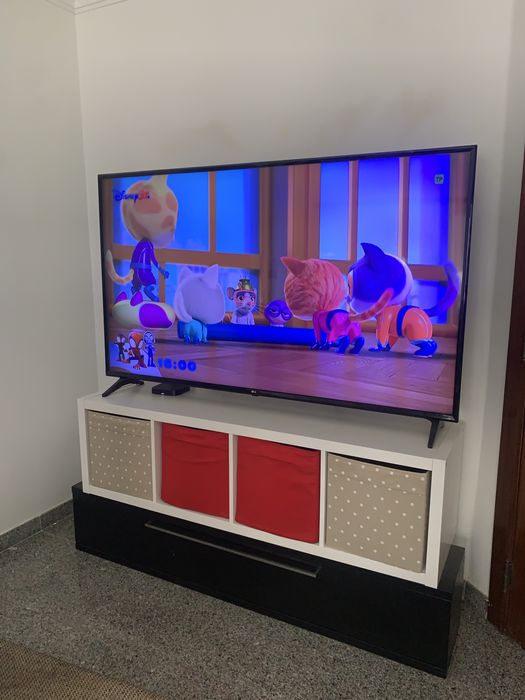 Tv 65 com movel branco e preto e gavetas