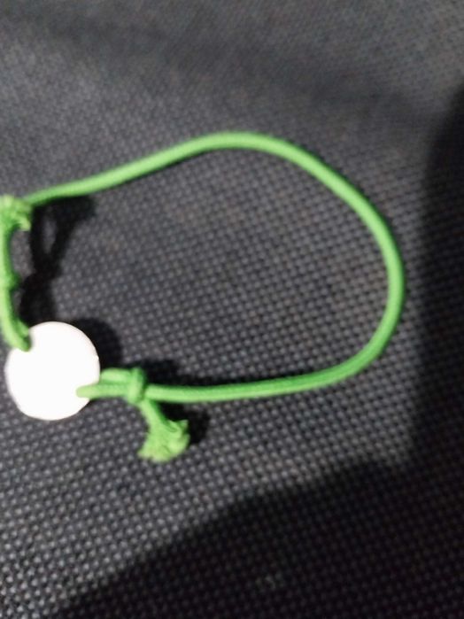 Pulseira de nós, verde, com mensagem “Por um mundo melhor”
