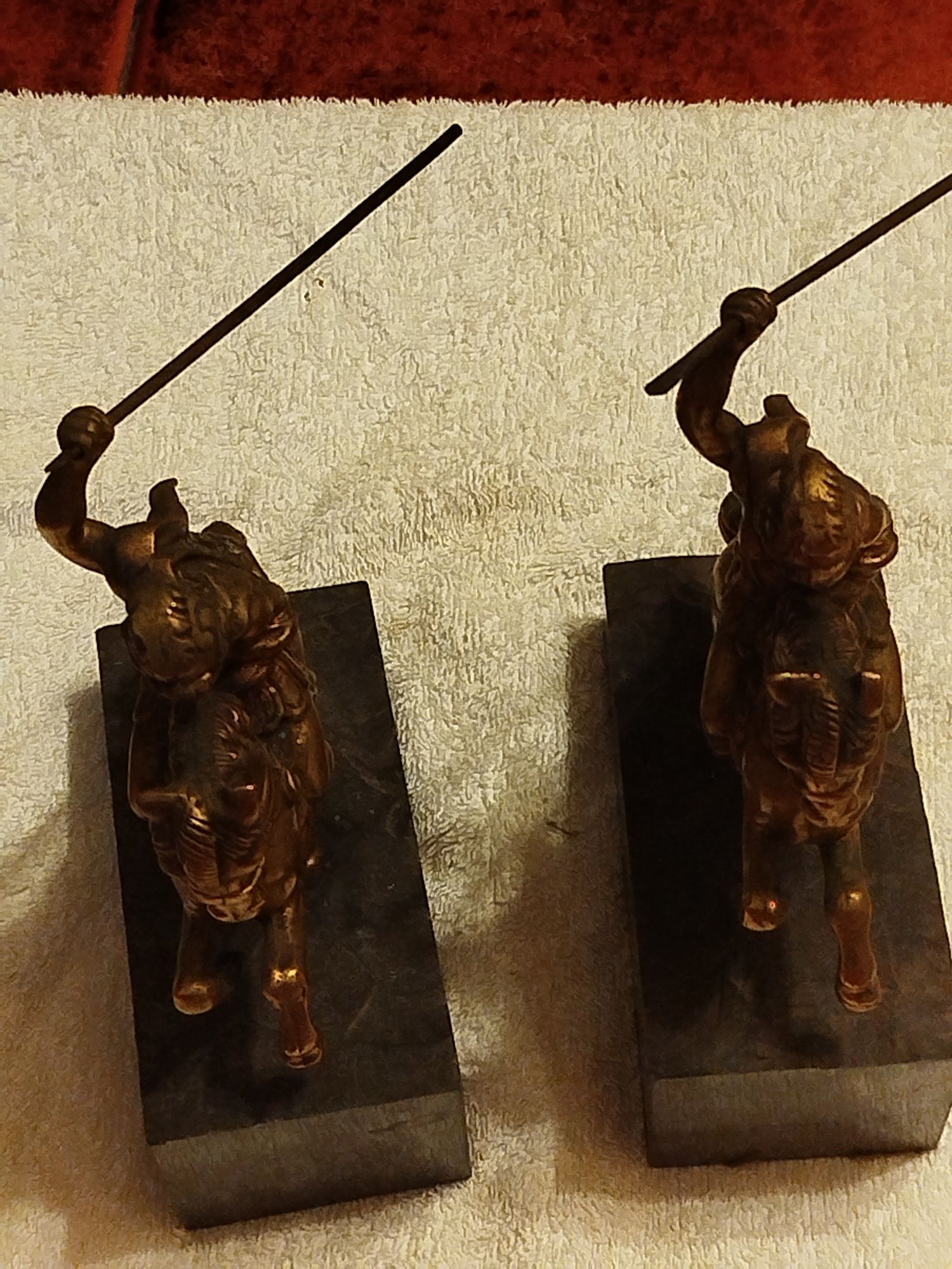 Duas esculturas antigas de um guerreiro em bronze e bases de mármore