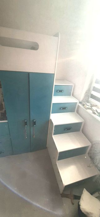 Łóżko piętrowe z biurkiem i schodami.