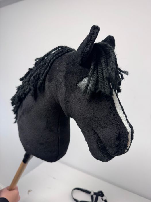 Piękny czarny hobby horse z kantarem i lonżą