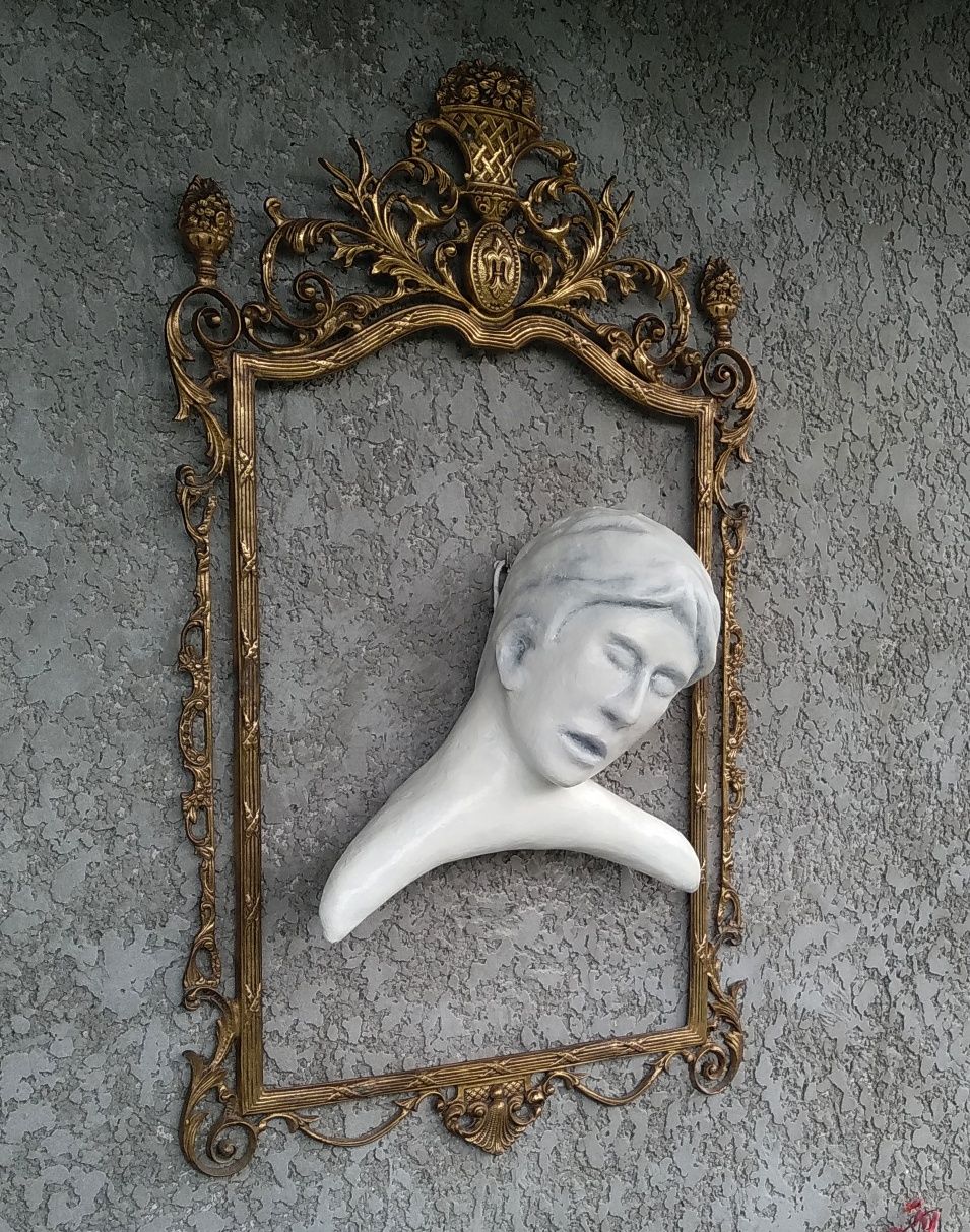 Escultura com moldura em metal amarelo