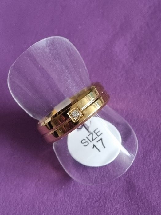 Anel/aliança dourado, em aço inoxidável, com 1 brilhante. T17