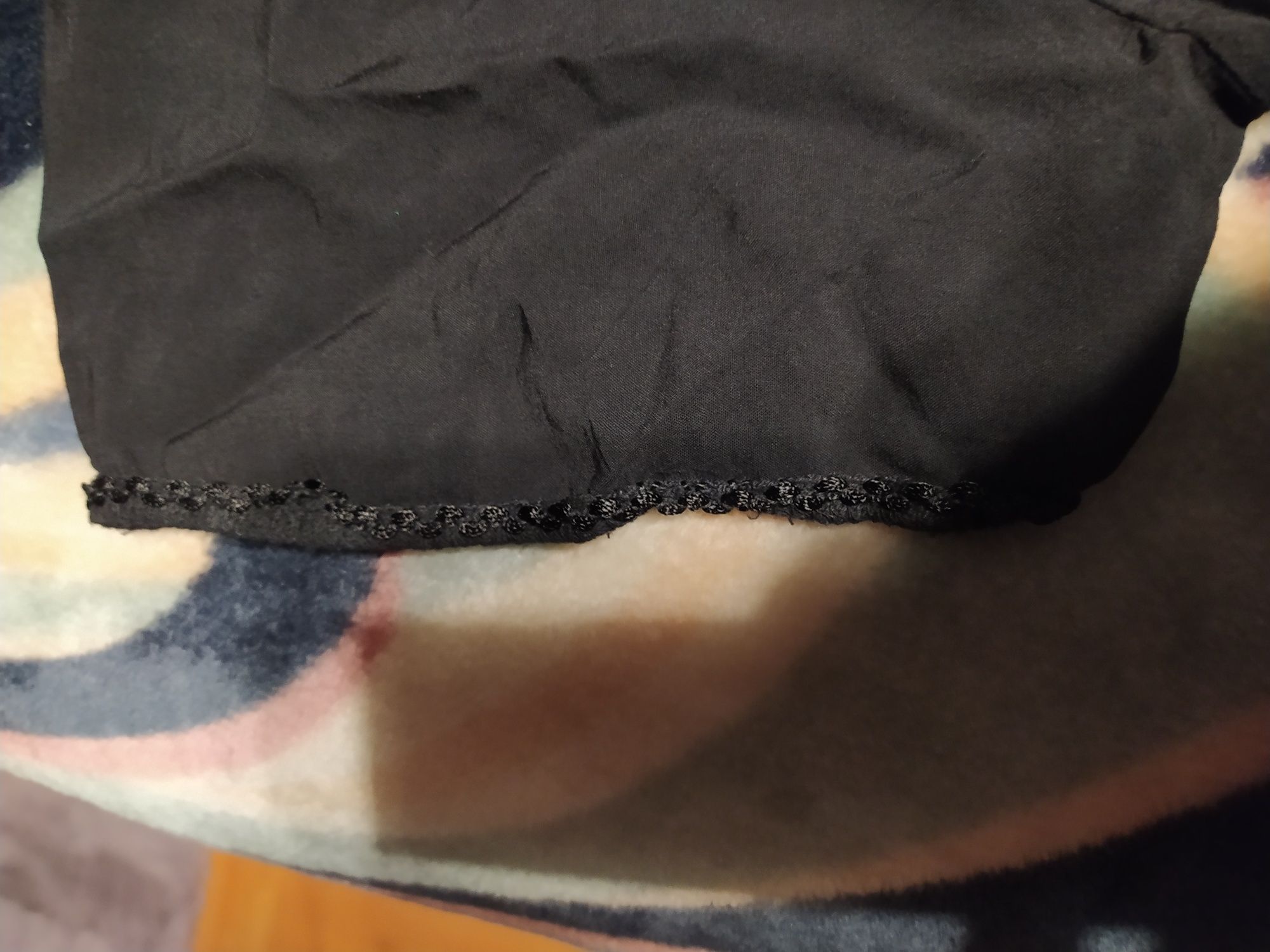 Czarna bluzka zakończona falbanką z koronką.
