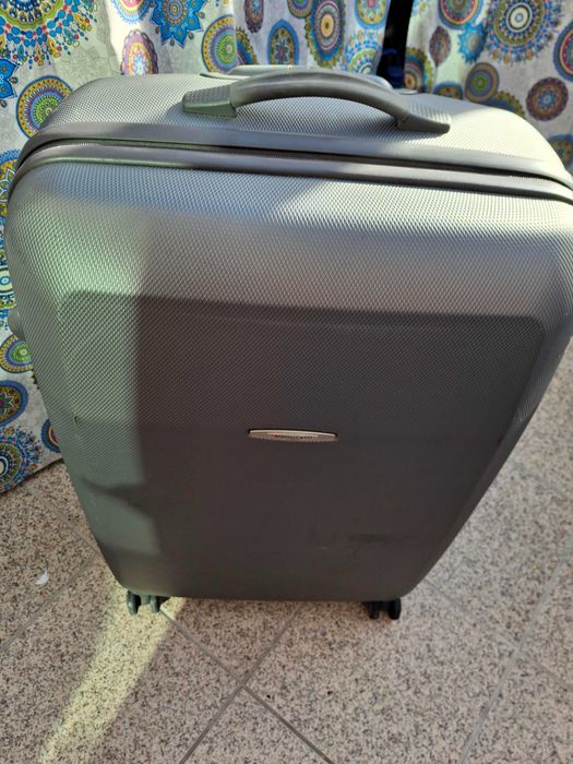 Mala de viagem cinzenta rígida com muito boa capacidade .