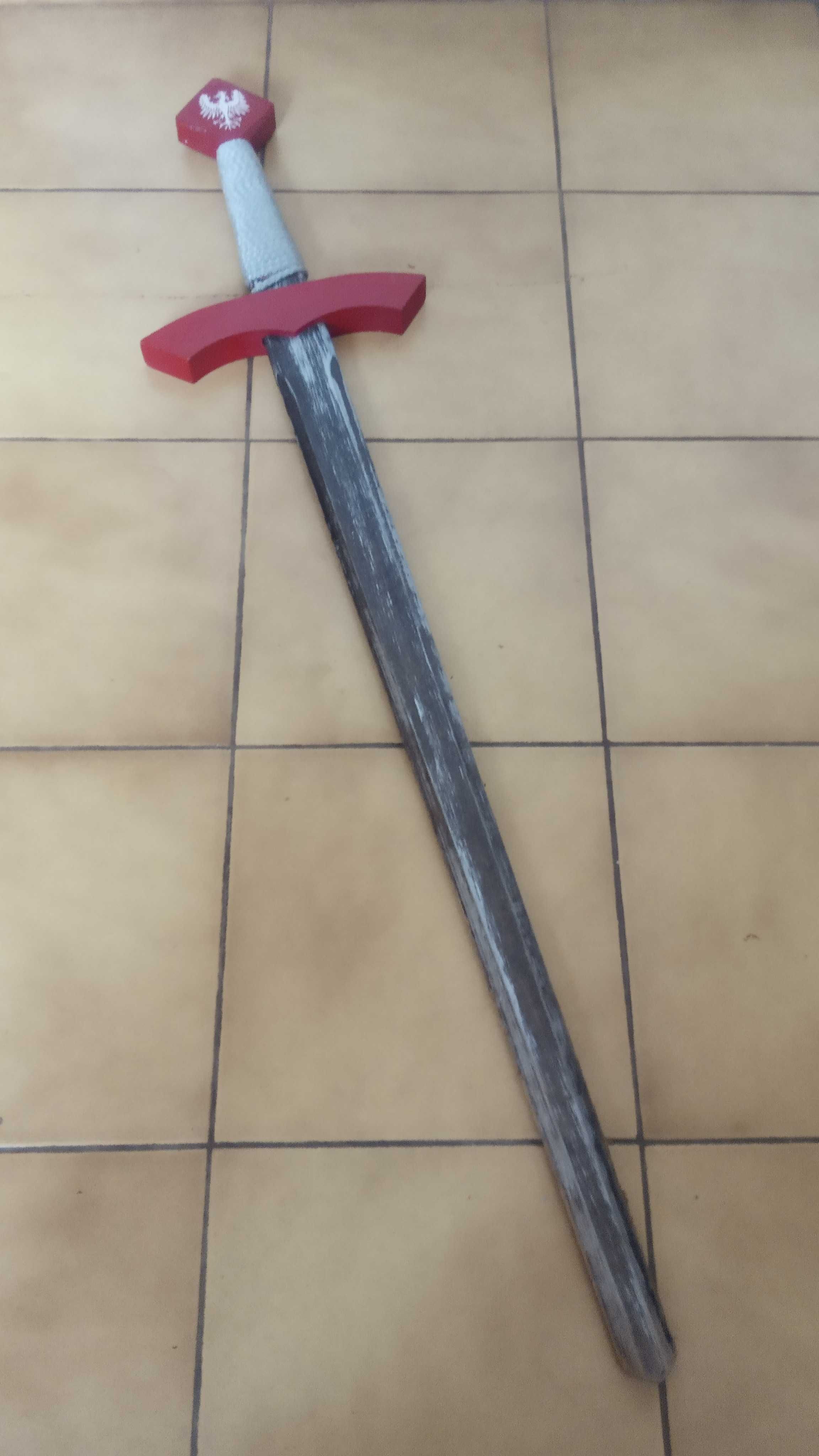Miecz drewniany z czerwonym pokrowcem na pasku, z orłem