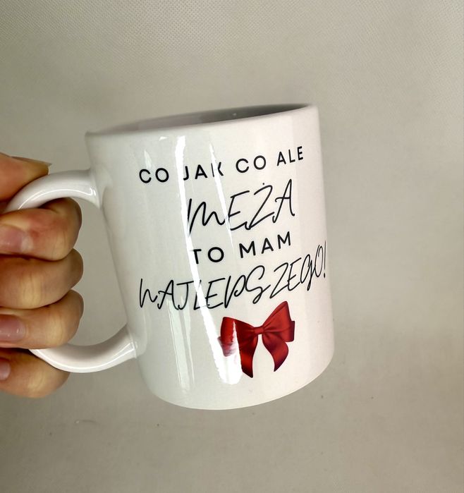 Biały kubek z czerwoną kokardką, prezent na mikołaja