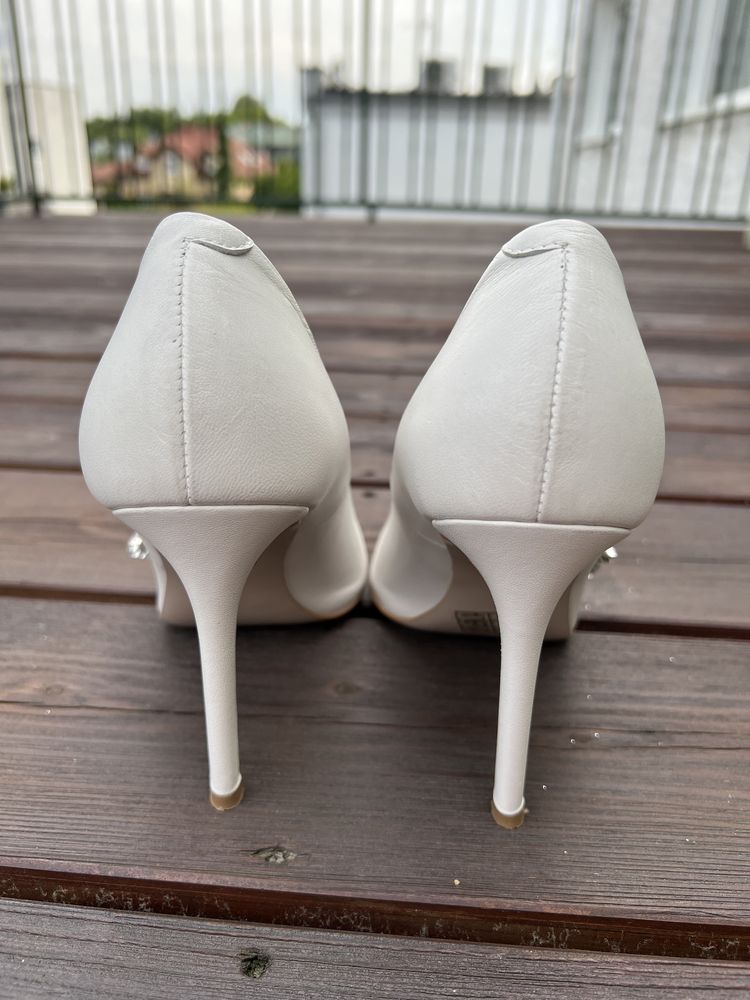 Białe ślubne buty na szpilce z wyjątkową, srebrną ozdobą